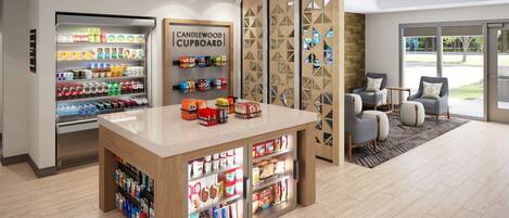 A modern kitchenette with a built-in refrigerator, a coffee station, and a seating area with chairs and a table.