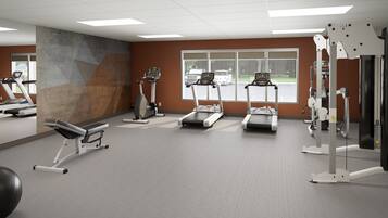 A gym with treadmills, a bench press, and a weight machine.