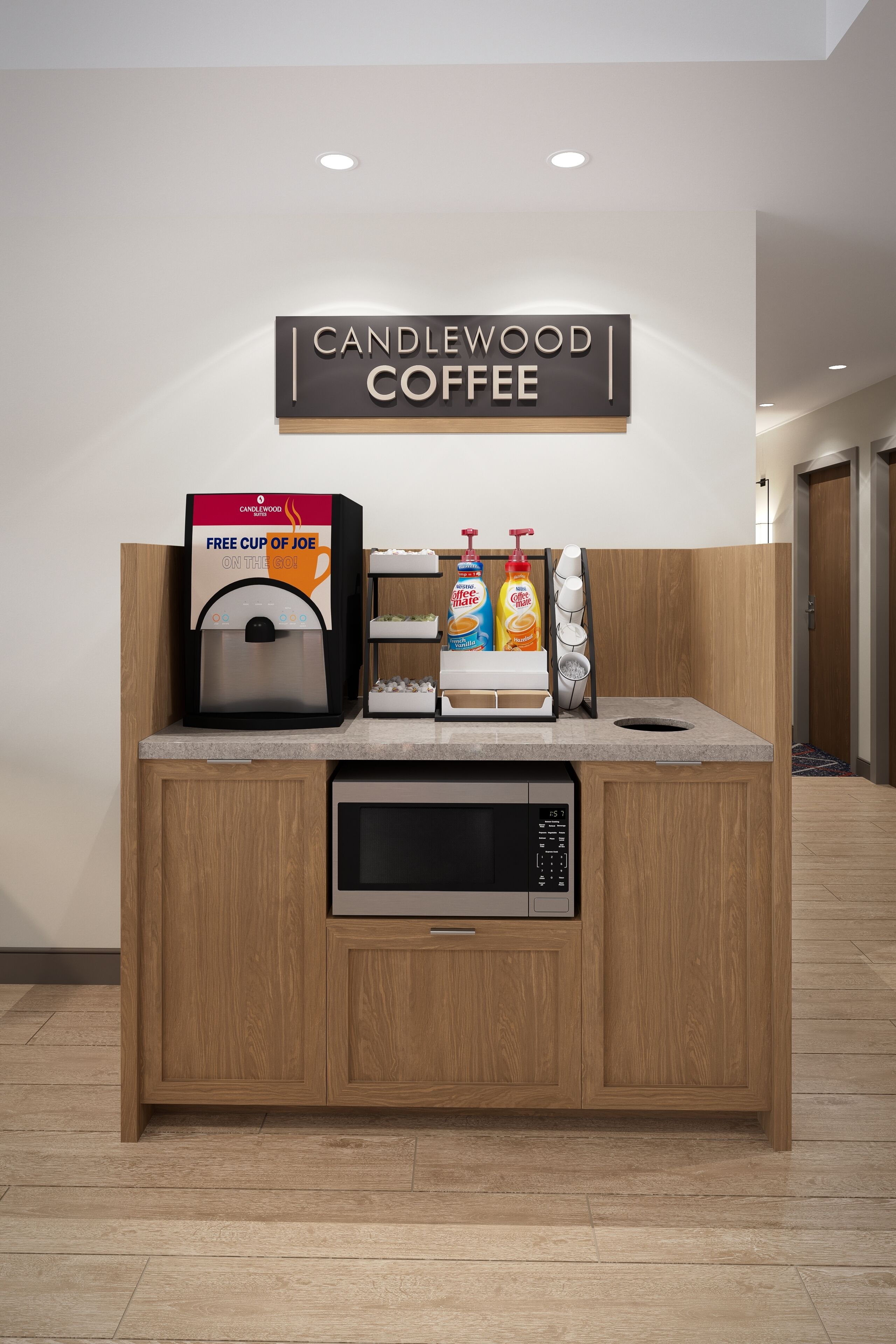 Eine Kaffeestation mit einer Kaffeemaschine, einem Schild mit der Aufschrift „CANDLEWOOD COFFEE“ und einem Angebot kostenloser Tassen.
