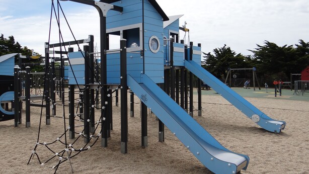 A playground with a blue slide and climbing structures.