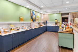 A modern breakfast area with a long counter, various food items, and a coffee station. - Spark by Hilton Dothan (Dothan)