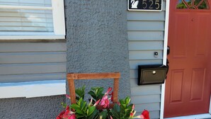Una casa con una cassetta delle lettere, un numero civico e una porta rossa.