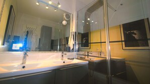 Un bagno moderno con due lavabi, un ampio specchio e cabina doccia in vetro.