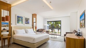 Una habitación de hotel moderna con una cama grande, un escritorio y un balcón con vistas.