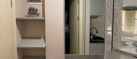 Une petite salle de bain comprenant des toilettes, un lavabo, un miroir et un petit meuble de rangement.