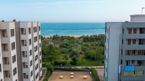 A swimming pool with a view of the sea, surrounded by buildings. - [lido Adriano] Appartamento con Vista Mare (lido adriano)