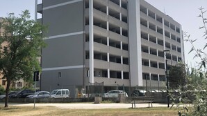 A multi-story parking garage with a modern design, featuring a central vertical column and multiple levels of parking spaces. - [lido Adriano] Appartamento con Vista Mare (lido adriano)