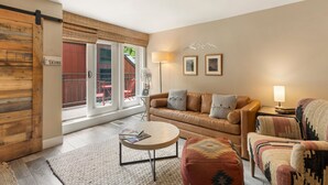 Uma sala de estar com sofá, poltrona e mesa de centro.