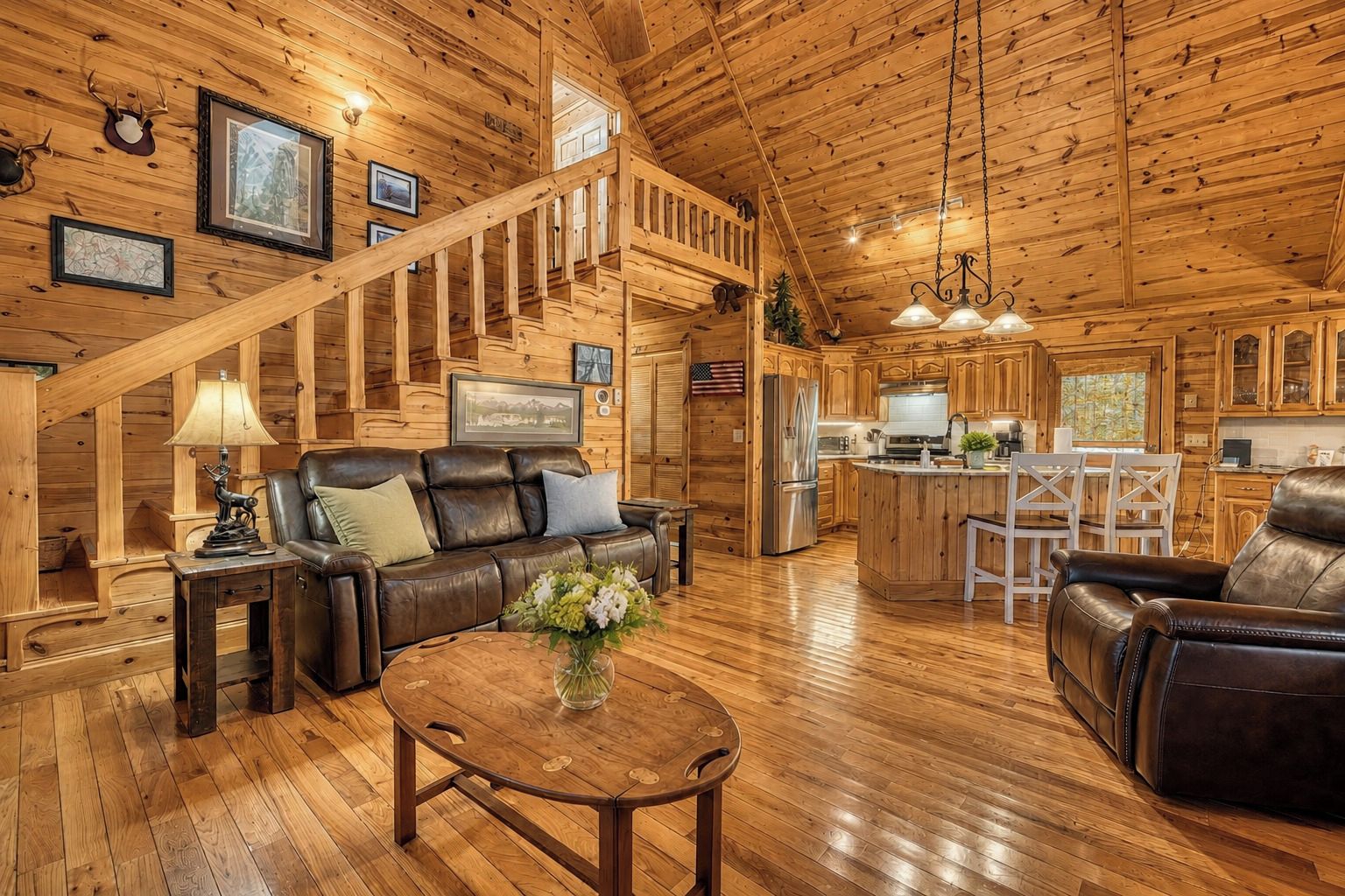 A spacious log cabin interior with a living area, dining space, and kitchen.