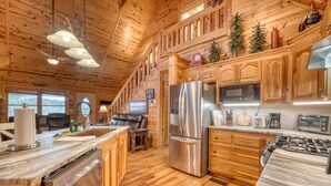 A spacious kitchen with wooden cabinets, stainless steel appliances, and a large island. - Rocky Top Retreat  Hot Tub & Mountain Views (Suches)