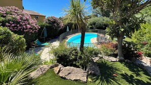 A swimming pool surrounded by lush greenery and flowering plants. - Magnifique Haut de Villa , Dans Impasse Calme, Piscine, 300m MER (Cavalaire-sur-Mer)