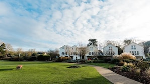 A residential area with white houses, a green lawn, and a pathway.