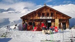 A wooden mountain hut named RUSCHEIN with a snow-covered landscape in the background. - Renovated 3 Rooms Apartment in Ruschein Near Laax (Ilanz)
