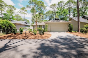 A residential area with houses, a driveway, and a garage. - 12 Isle of Pines - Golf Course View, Sea Pines Retreat (Hilton Head Island)