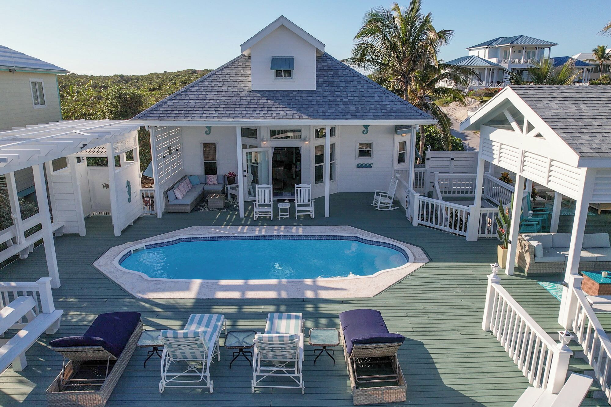 A pool area with lounge chairs and a hot tub.