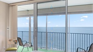 A balcony with a view of the sea, a chair, a table, and a small plant. - English Towers-Beautiful Direct Ocean Views from this Remodeled Condo! (Ocean City)