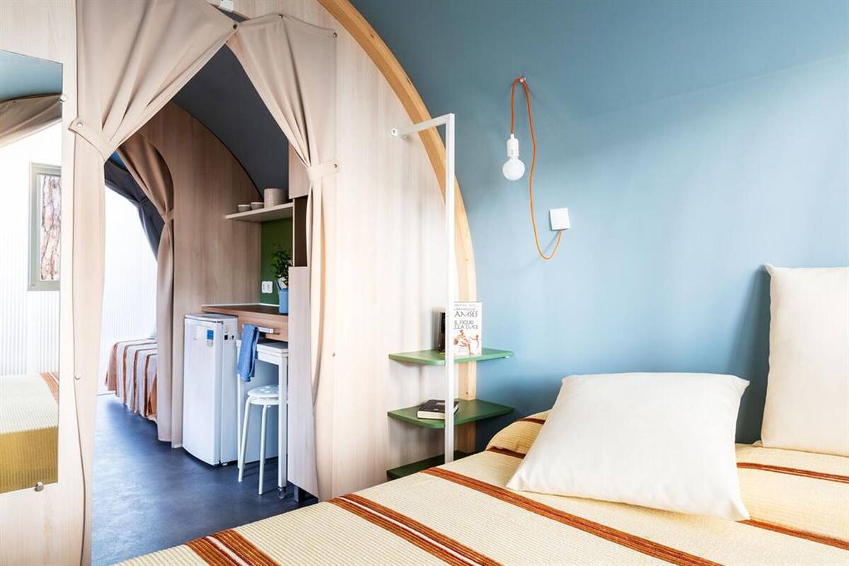 Un dormitorio con una cama, un escritorio y una silla.