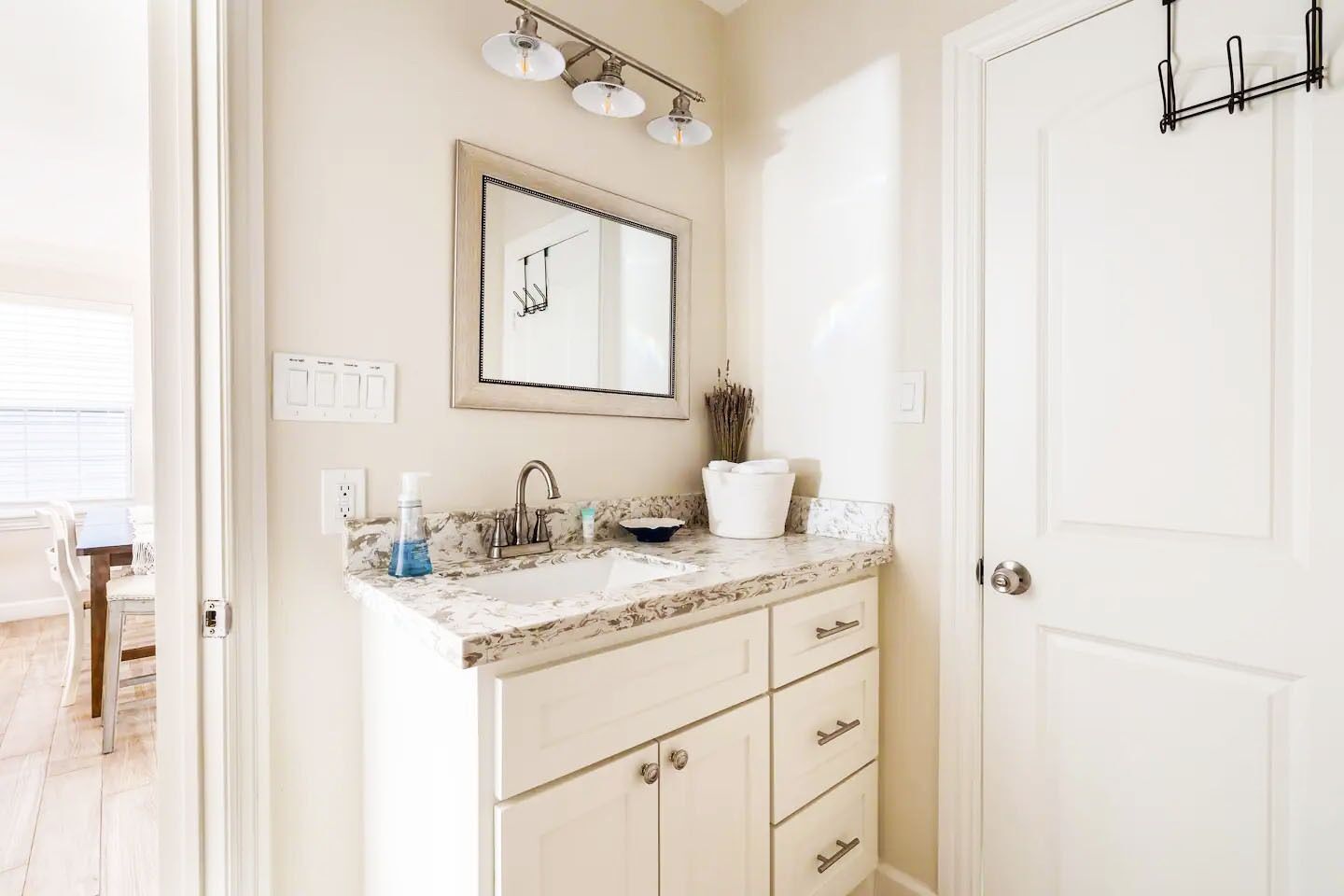 Une salle de bain avec un comptoir en marbre, un lavabo, un miroir et un porte-serviettes.