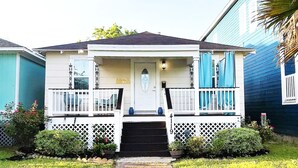 Une maison à deux étages avec un porche à l’avant, une boîte aux lettres et le numéro « 419 » affiché sur la façade.