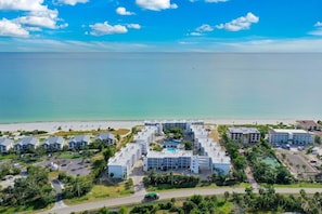 Un complexe hôtelier comprenant plusieurs bâtiments, une piscine et offrant une vue sur la plage.