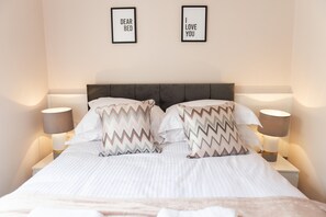 Cozy retreat with a large bed, two bedside tables, and framed artwork.