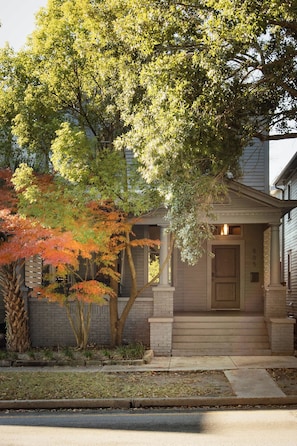 A residential house with a brick facade, a front porch, and a number '505' on the door.