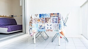 Quarto com uma cama, uma mesa com uma colagem de imagens e uma cadeira.