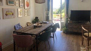 Comedor con mesa de madera, sillas y televisor.