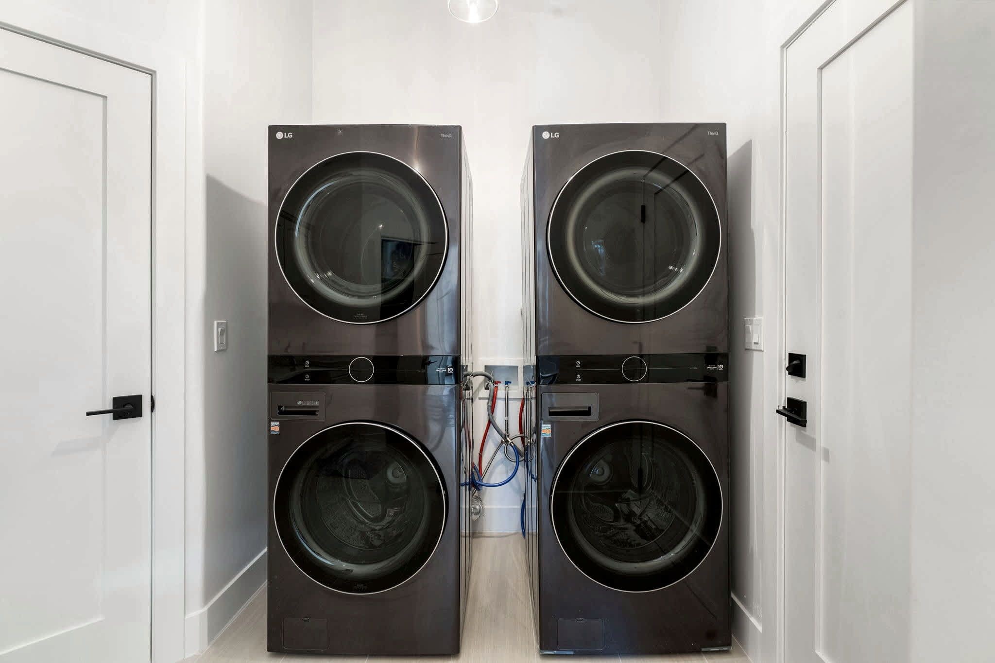 Large laundry room with dual washer and dryer stacks