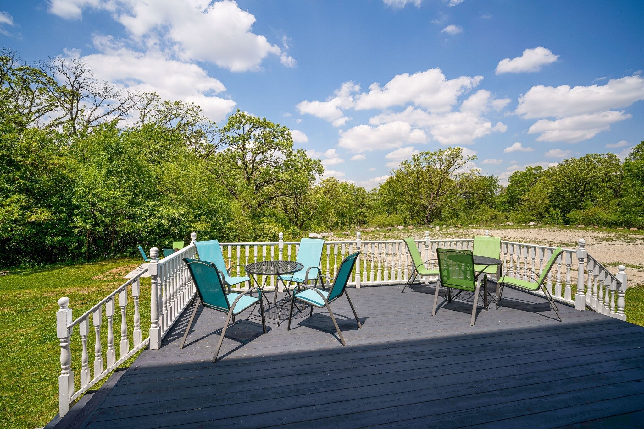 A deck with outdoor seating and a view of the beach.