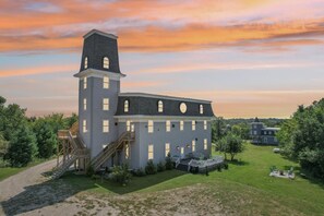 A large, two-story building with a prominent tower, a covered deck, and a well-maintained lawn. - Starlight Tower Suite 1 Bedroom With Stunning Views 1 Villa by RedAwning (Fort Atkinson)