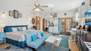 Une chambre moderne comprenant un lit, un canapé, un bureau et un coin cuisine.