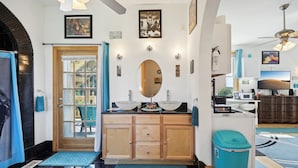 Une salle de bain moderne avec un meuble-lavabo à deux vasques, un grand miroir et un ventilateur de plafond.