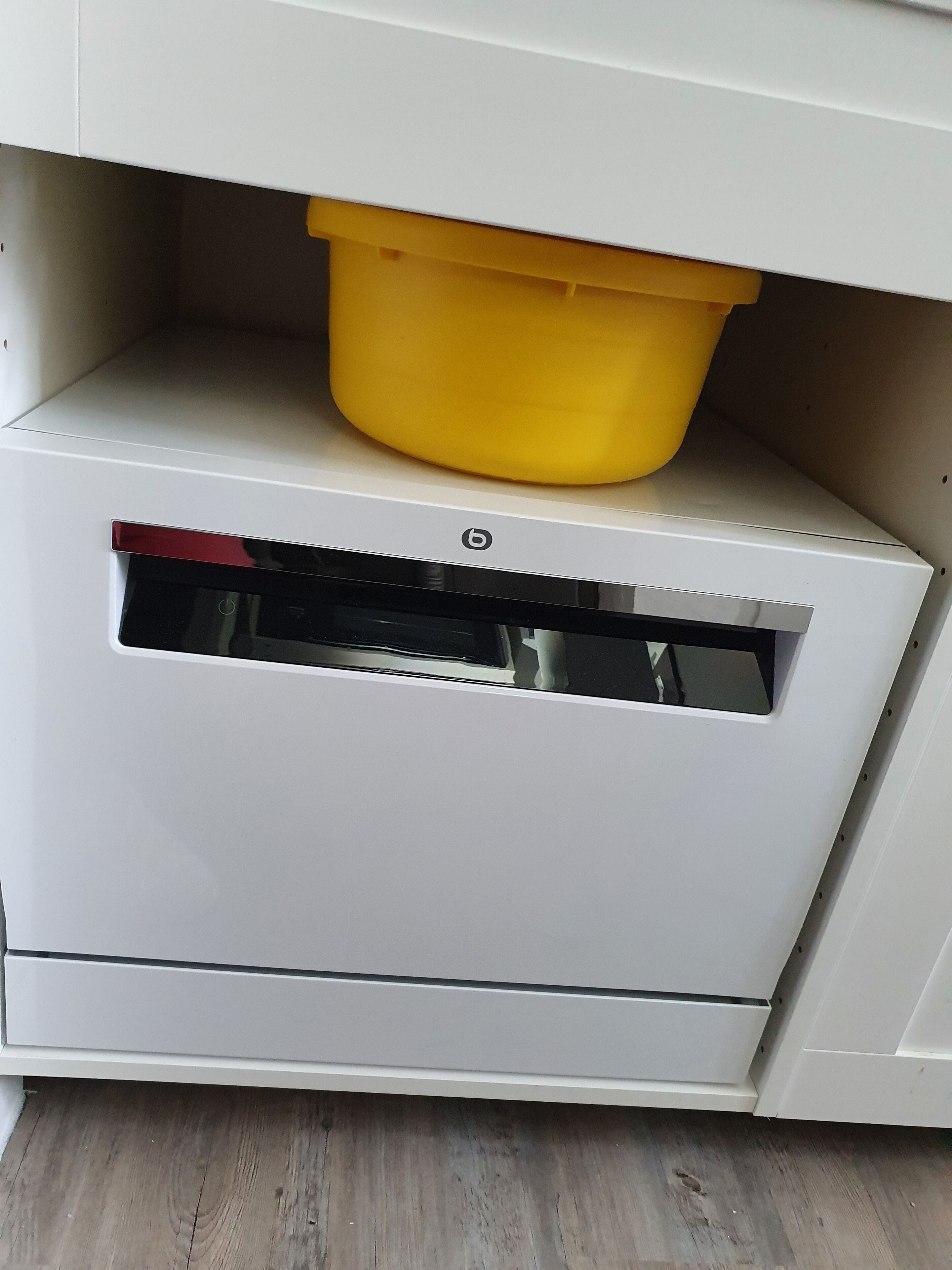 Un mobile bianco con un contenitore giallo sopra.