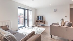 Ein modernes Wohnzimmer mit einer Couch, einem Couchtisch und einer TV-Konsole.
