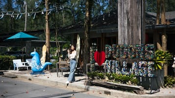 A storefront with a wooden exterior, a blue decorative fish sculpture, and a heart-shaped sign.