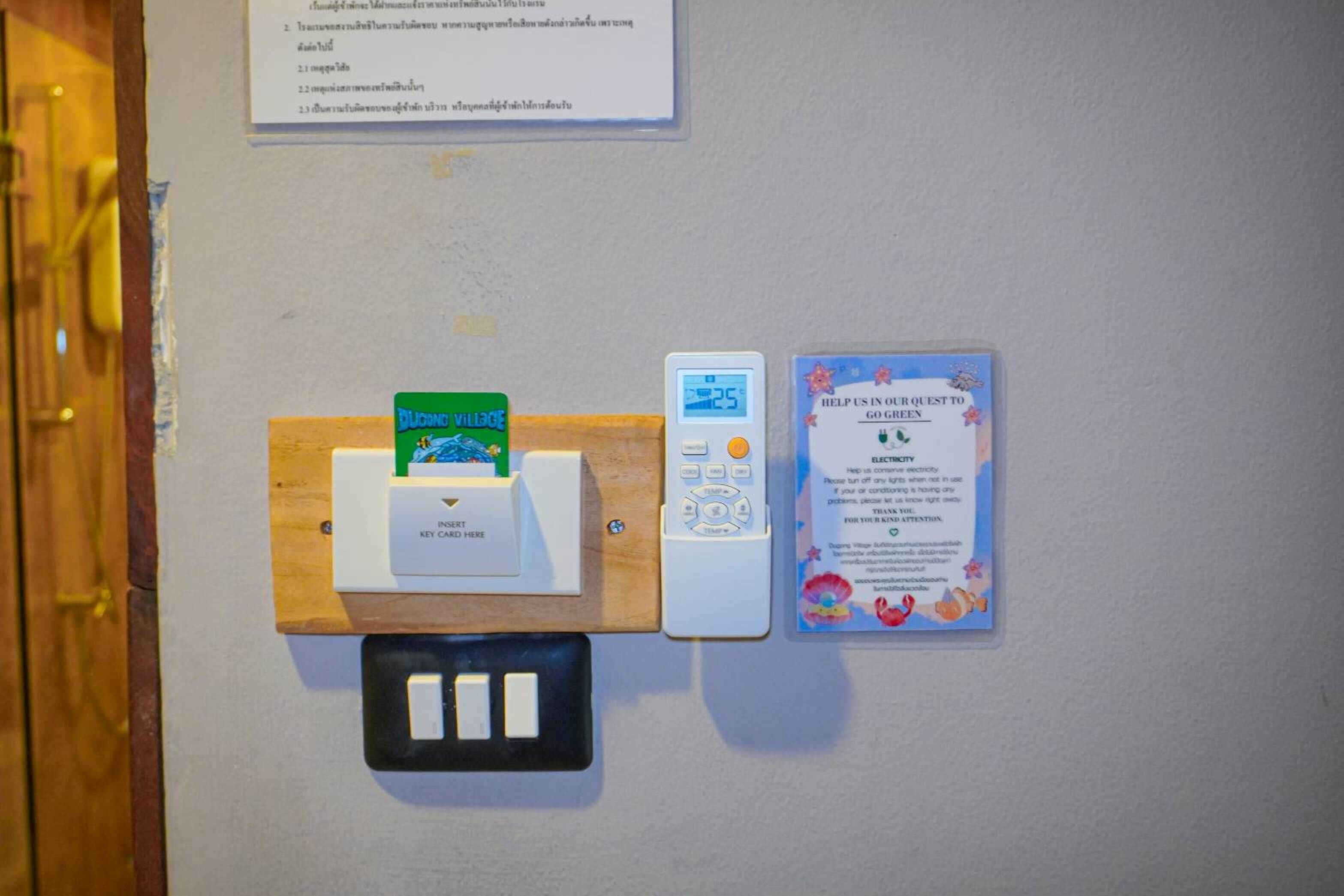 Ein wandmontiertes Schlossystem, ein digitales Thermostat und ein Schild zur Förderung des Energieeinsparens.