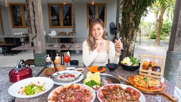 Comedor con diversos platos, como ensaladas, carnes y una pizza, sobre una mesa de granito.