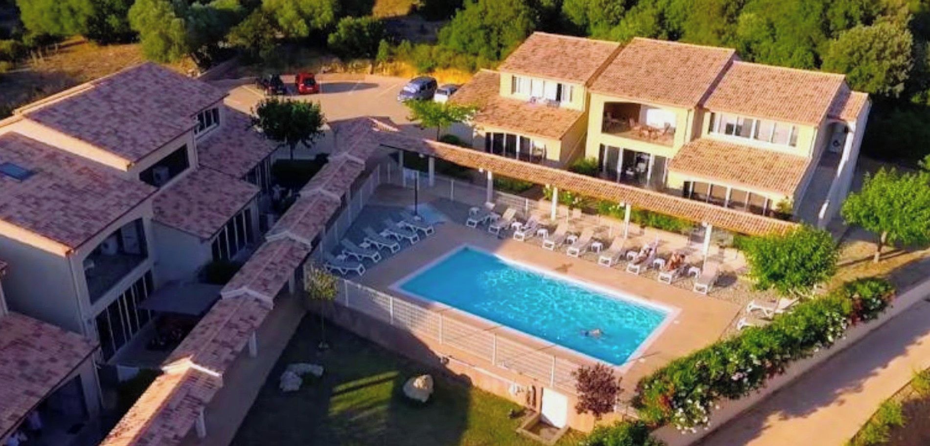 A residential area with a swimming pool surrounded by lounge chairs and a covered patio.