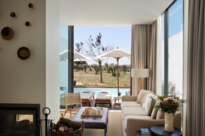 Una sala de estar moderna con vista a una piscina, una chimenea y un comedor con mobiliario exterior.