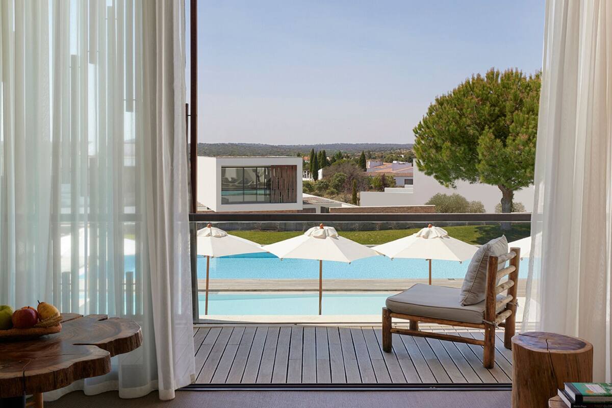 Ein Balkon mit Pool, einem Stuhl, einem Tisch mit Obst und einer Sitzecke.