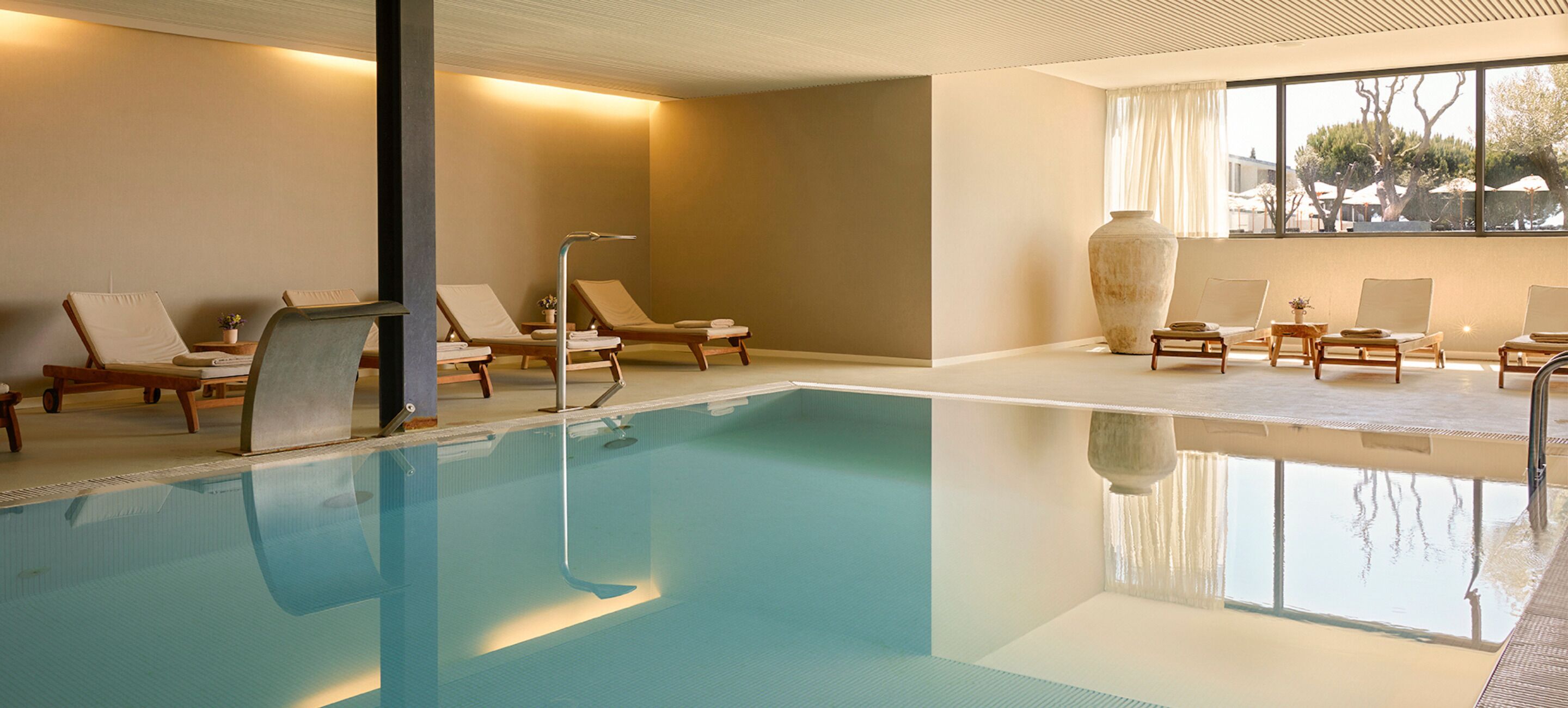 A swimming pool with lounge chairs and a large vase.