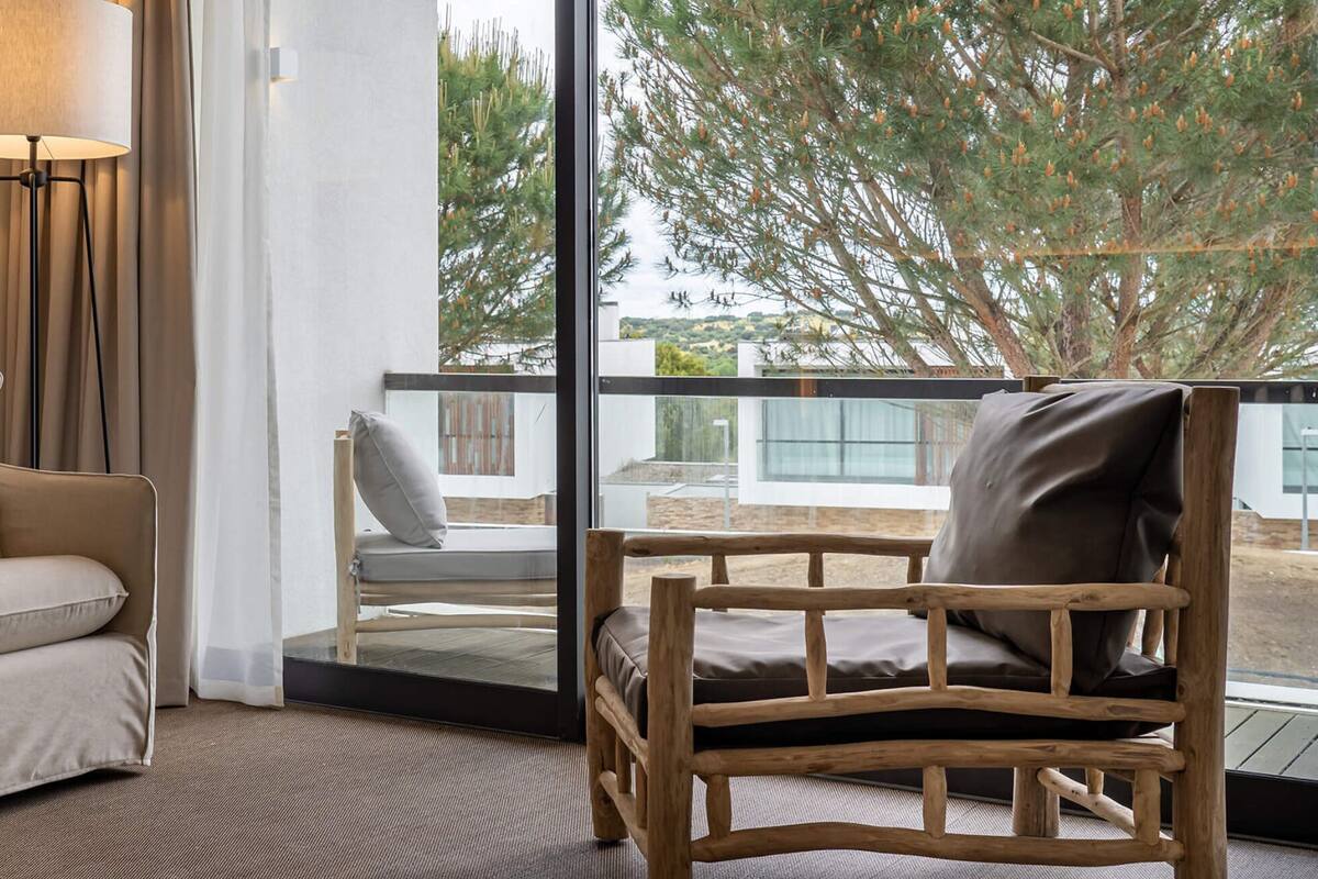Ein modernes Wohnzimmer mit einem beigen Sofa, einem Holzstuhl und einer Stehlampe.