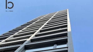 A modern building with a prominent 'Neko Yard' sign. - b hotel Neko Yard | Modern City-Center Studio (Naka Ward, Hiroshima)