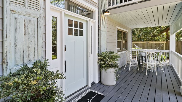 A porch with a white railing, a table, and chairs. - 3 bedroom, short walk to the beach with an amazing game room! (Hilton Head Island)
