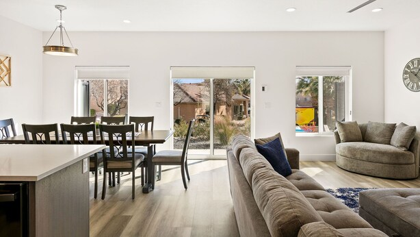 Un espacio habitable amplio con una mesa de comedor, sillas, un sofá y un ventilador de techo.