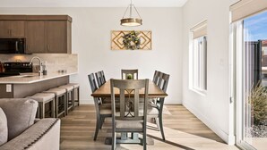 Una cocina moderna con armarios de madera oscura, microondas de acero inoxidable y una barra.