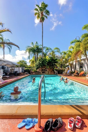 Una piscina al aire libre, sillones reclinables de piscina