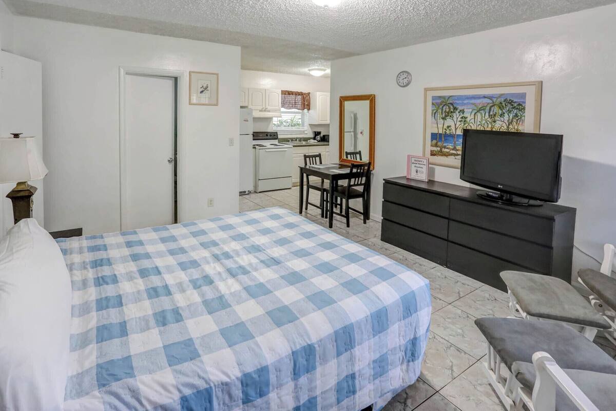 A hotel room with a bed, a television, a desk, and a chair.