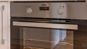 Een moderne keuken met een inbouwoven en een digitaal bedieningspaneel.